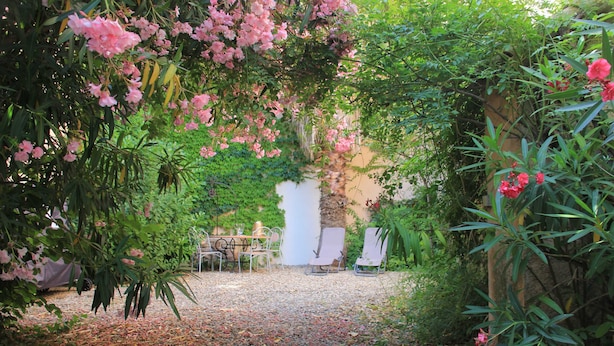 A garden pathway with a gravel surface, surrounded by lush greenery and flowering plants. - Large Art Nouveau house between sea and garrigue, charm and leisure in the heart of the South of France (Gabian)
