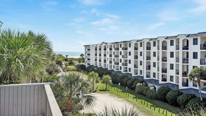 Ein Hotel mit mehreren Balkonen, Meerblick und einem gepflegten Garten.