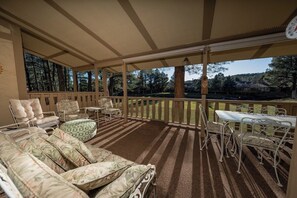 A covered outdoor area with a sofa, chairs, and a table.