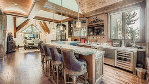 A spacious kitchen with a large island, bar stools, and a dining area with a table and chairs. - Immaculate Golf Course Home, Private Hot Tub, Gym, Firepits (Beaver Creek)
