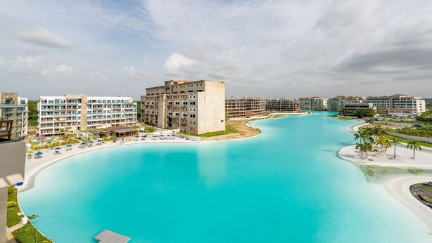 A resort with a large turquoise pool, multiple hotel buildings, and a sandy beach area. - Luxury Stay 2BDR with Private Artificial Beach (Cartagena de Indias)