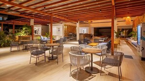 A spacious indoor area with wooden beams on the ceiling, multiple seating arrangements including tables and chairs, and potted plants. - Luxury Stay 2BDR with Private Artificial Beach (Cartagena de Indias)