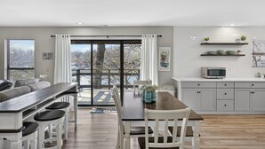 Una cocina moderna con microondas, armarios blancos y vista a un lago.