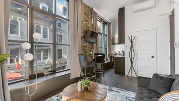 Suite estudio Deluxe, vista a la ciudad | Área de sala de estar