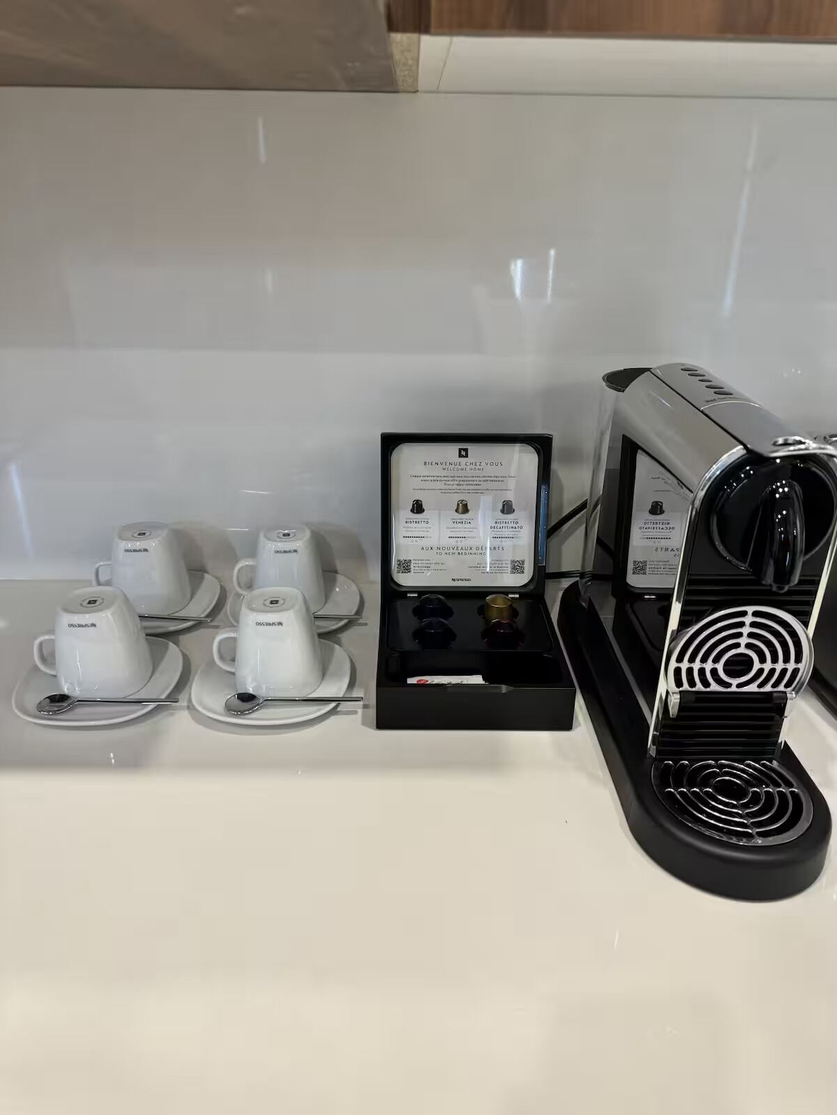Una estación de café con una máquina de café, tazas y un menú.