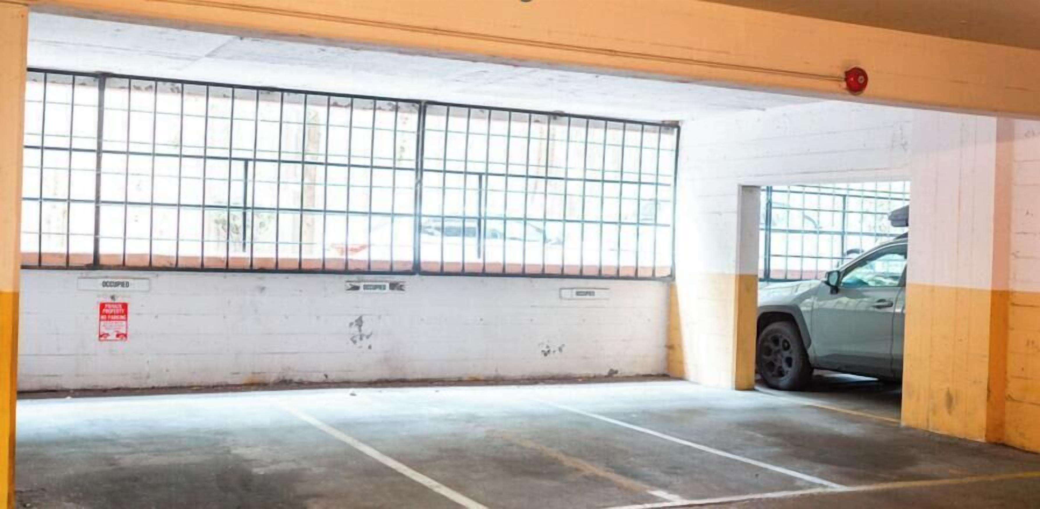 A parking garage with concrete floors and metal railings.