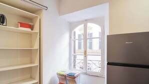 A kitchen with a refrigerator, a window with a view, and a set of colorful storage bins.