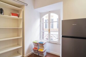 Eine Küche mit Kühlschrank, Fenster mit Blick und mehreren farbigen Aufbewahrungsboxen.