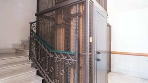 Una escalera con barandilla de metal y una puerta con manija.
