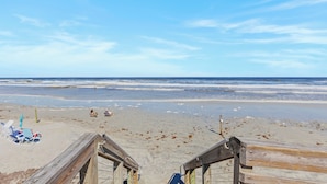 Une plage avec des promenades en bois, des chaises de plage et des parasols.