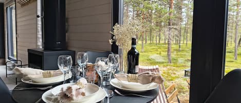 A dining table set outdoors with a view of a forest.