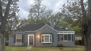 A single-story house with a grey exterior, a front door, and two windows with shutters. - 3-bedroom house in charming Southhull neighborhood, close to downtown! (Montgomery)