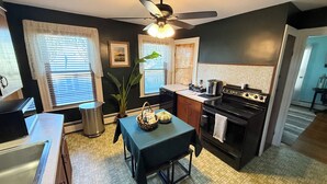 A compact kitchen with a central island, a stove, and a ceiling fan. - Gallows Hill Guest House, Charming 2BR Apartment on Gallows Hill in Salem, MA (Salem)