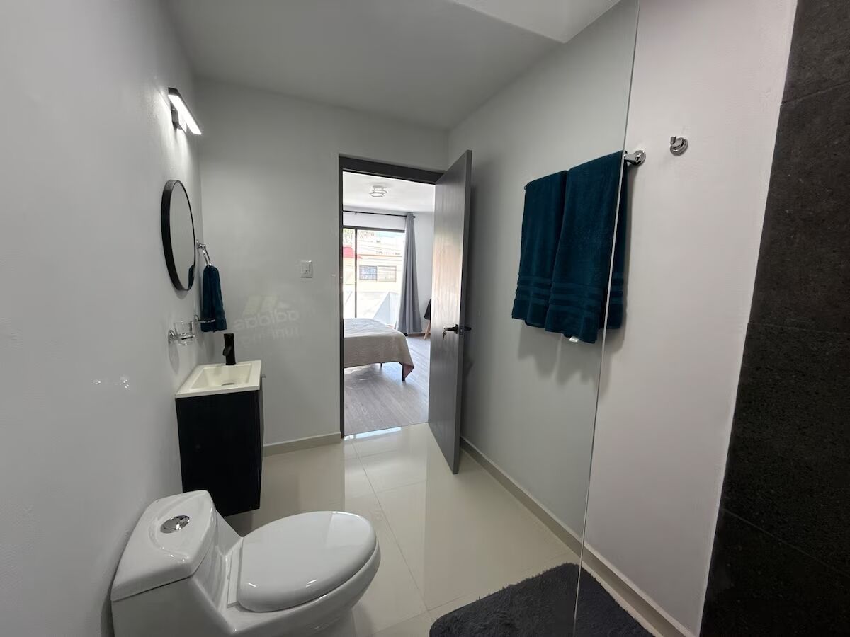 A modern bathroom with a toilet, sink, and towel rack.