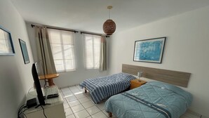 A bedroom with two beds, a desk with a computer, a chair, and a window with curtains. - Cozy Room w/ Private Bath + Shared Kitchen 5 Min to Beach -Surf Hostel Vibe (San Miguel)