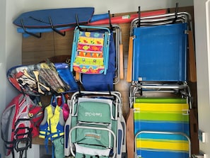 Ein Zimmer mit mehreren Stühlen und einem Bett, einige mit bunten Überzügen.