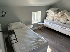 A bedroom with a bed, a small round table, a window, and a mattress with pillows. - Drôme Provençale Detached house in 18th century property, tennis access (Pierrelatte)