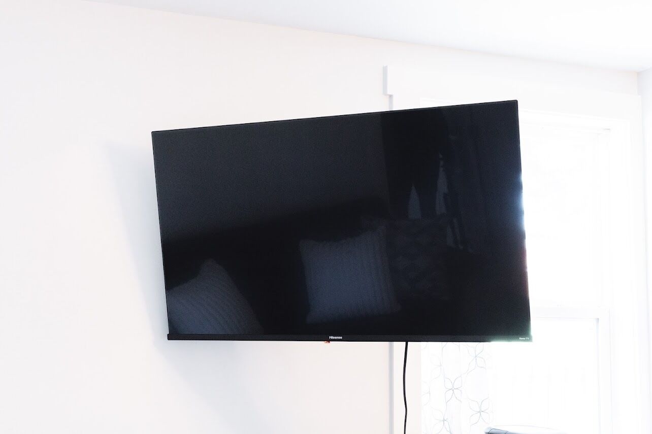 Een flatscreen televisie bevestigd aan een witte muur.