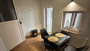 A dining area with a table, chairs, and a small stove. - Beautiful penthouse next to the subway enrichh lluchf (L'Hospitalet de Llobregat)