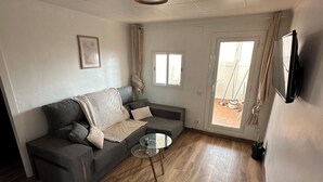 A modern living room with a grey sofa, a glass coffee table, and a wooden floor. - Beautiful penthouse next to the subway enrichh lluchf (L'Hospitalet de Llobregat)