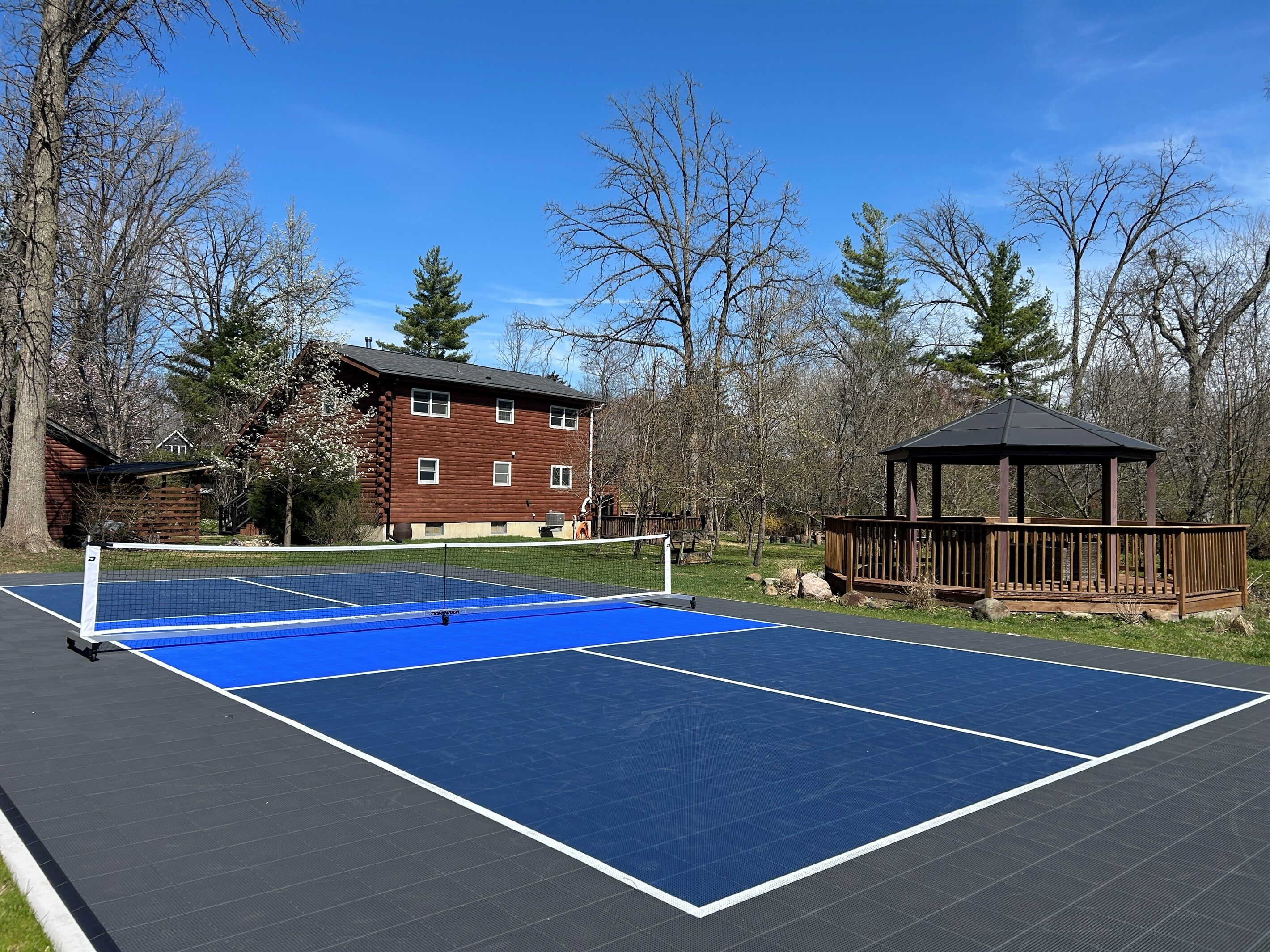 Private onsite regulation size pickleball court with Sport Court surface.