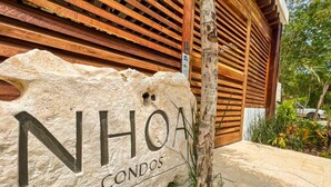 Ein Steinschild mit der Aufschrift 'NHOA CONDOS' für eine Wohnanlage.