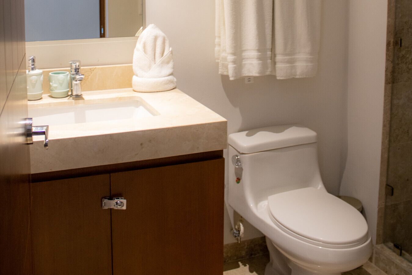 A bathroom with a sink, toilet, and towel rack.