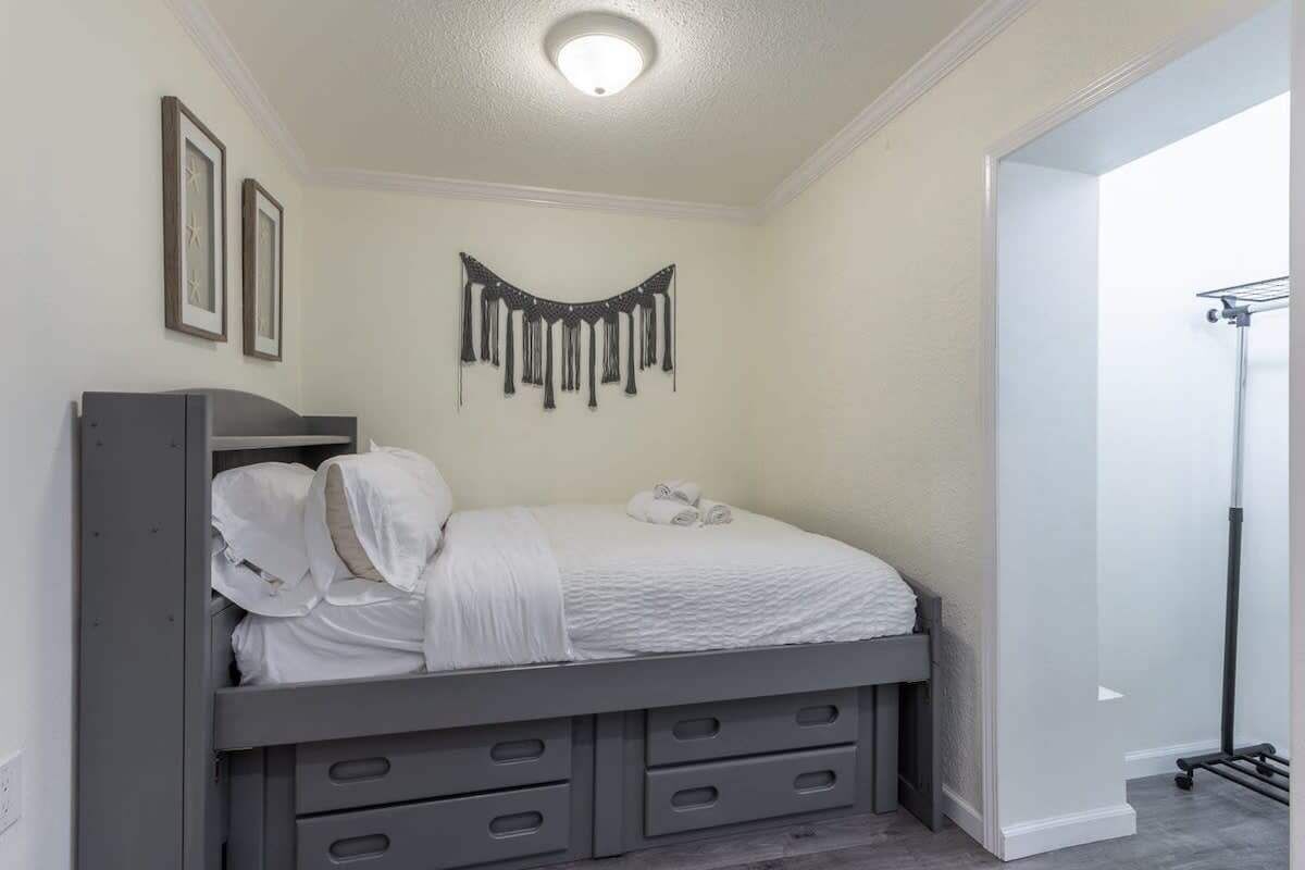 A bedroom with a bed, a wardrobe, and a wall-mounted decoration.