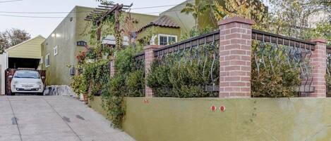 A residential property with a garage, a brick wall, and a metal gate.