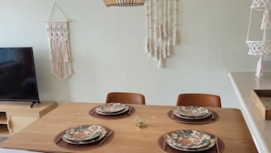 Een eetgedeelte met een houten tafel voor vier personen, omringd door lederen stoelen.