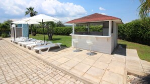 A poolside area with lounge chairs and a bar. - VILLA VENERA - Amazing Holiday House (Solarino)