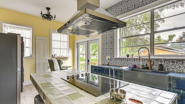 A modern kitchen with a large island, stainless steel appliances, and a view of the outdoors through large windows. - 2 Mi to Ybor City: Eclectic Tampa Charmer! (Tampa)