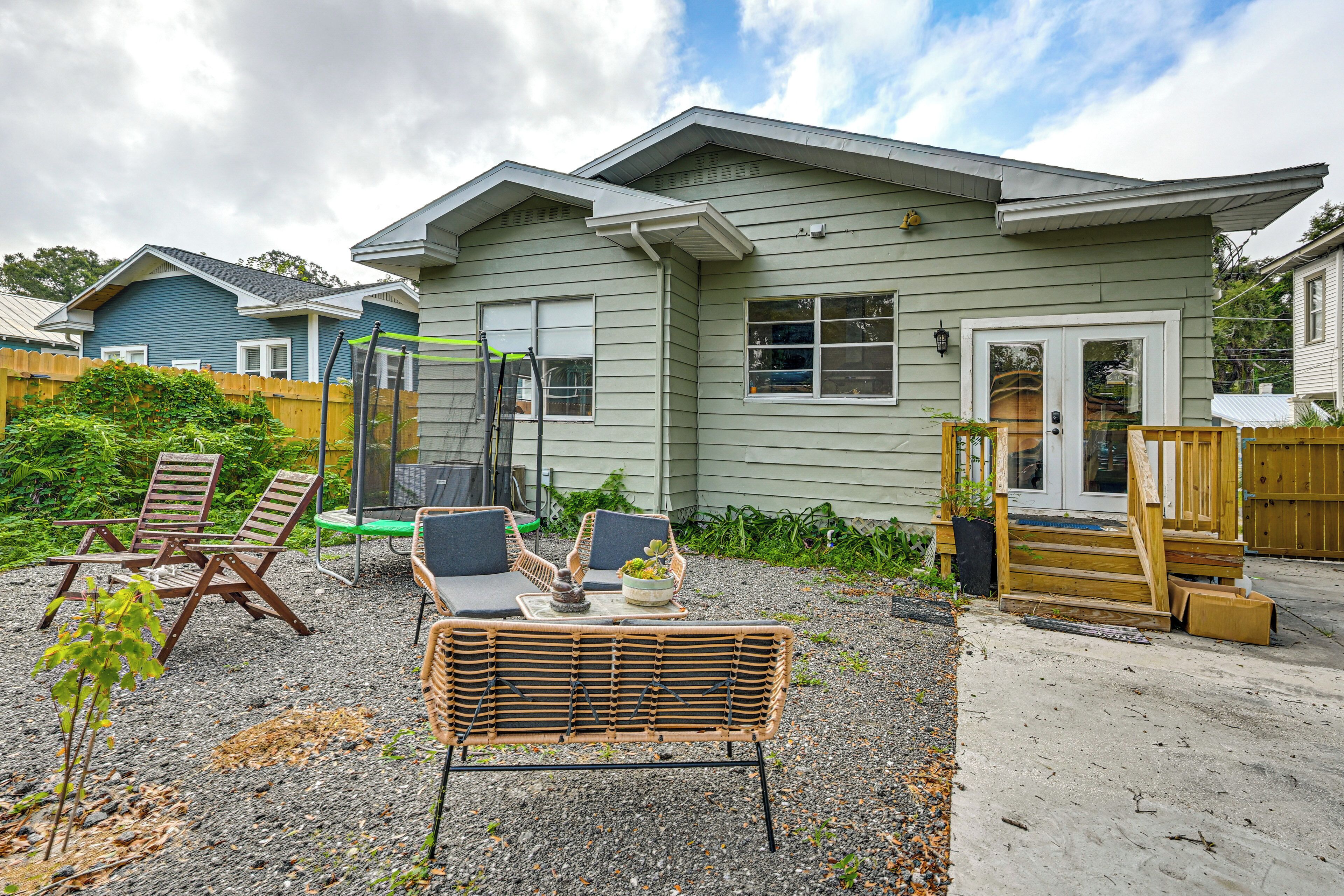 Une maison dotée d’un patio aménagé avec des meubles en osier et une petite table ornée d’une plante.