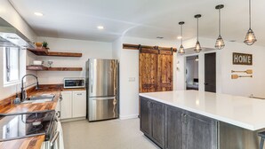 Una cocina moderna con encimeras de madera, electrodomésticos de acero inoxidable y una isla grande.