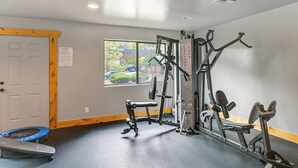 Et fitnessrum med træningsudstyr, en trampolin og et vindue med udsigt ud