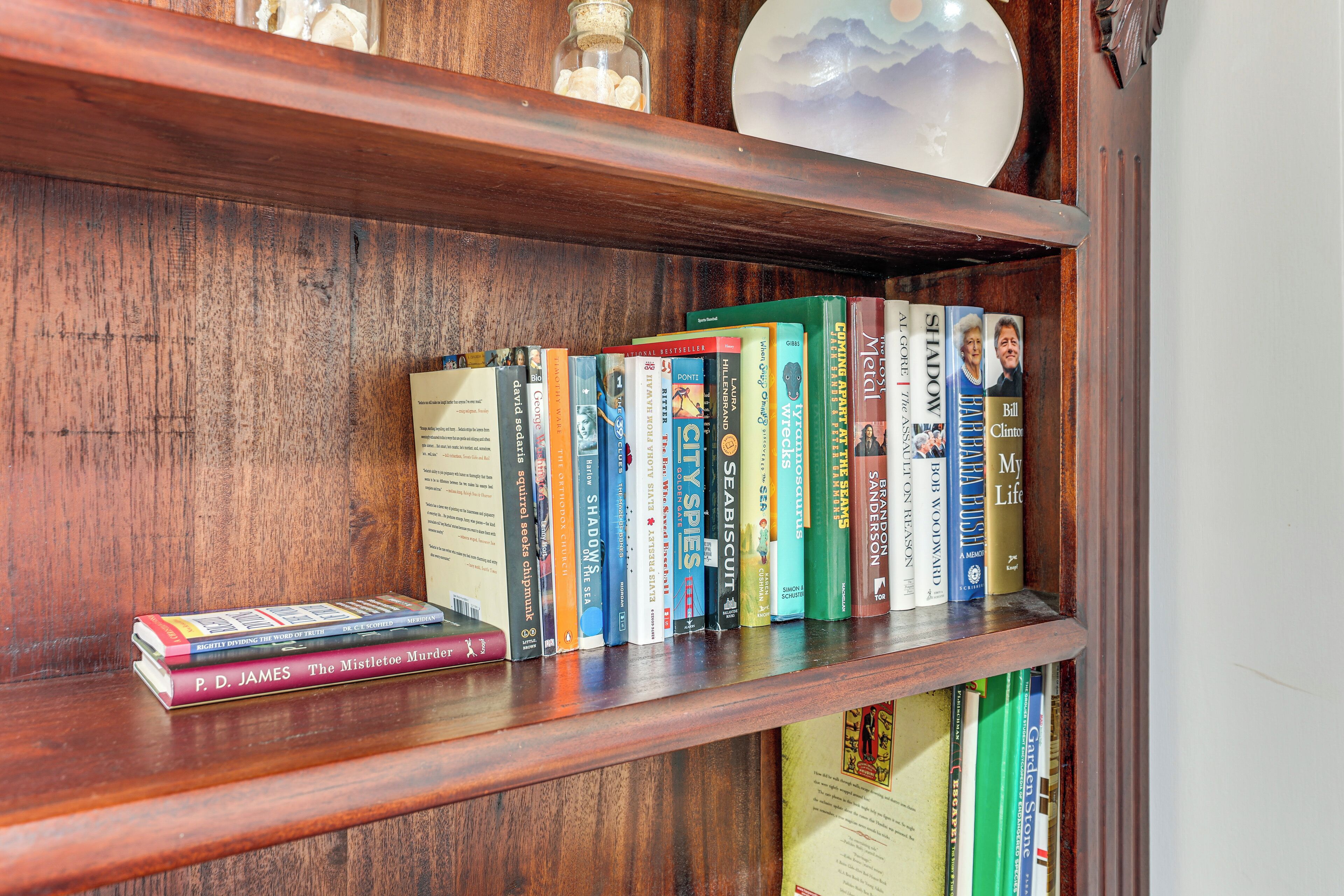 A wooden bookshelf with various books and a decorative globe.