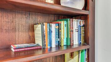 A wooden bookshelf with various books and a decorative globe.