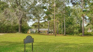 A grassy area with a stone marker and a house in the background. - 6 Mi to Clarks Hill Lake: Quiet Couple's Retreat (Appling)