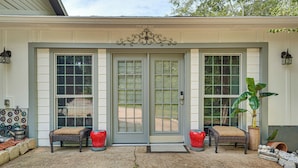A front porch with a double door, two wicker chairs with cushions, a potted plant, and a bird feeder. - 6 Mi to Clarks Hill Lake: Quiet Couple's Retreat (Appling)