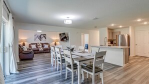 Uma sala de estar moderna com área de jantar, cozinha e banheiro.
