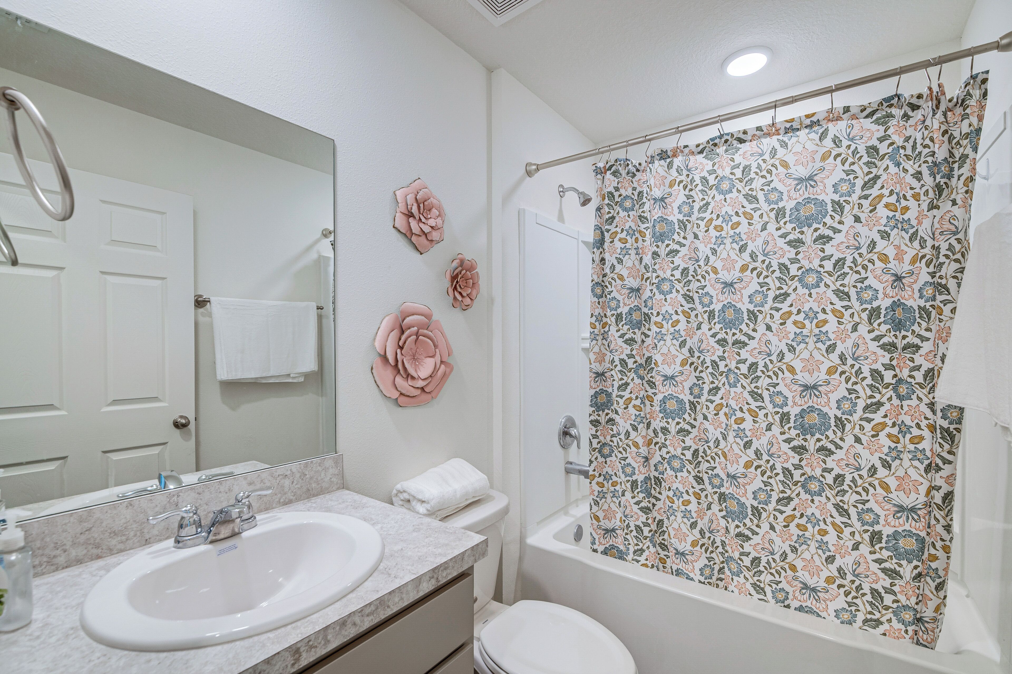 A bathroom with a double sink, toilet, and shower.