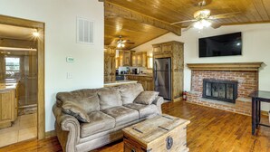A spacious living room with a leather sofa, wooden ceiling, and a fireplace. - Ozarks Waterfront Home w/ Dock & Marina Access (Warsaw)