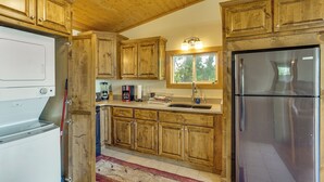 A kitchen with wooden cabinets, a stainless steel refrigerator, and a ceiling fan. - Ozarks Waterfront Home w/ Dock & Marina Access (Warsaw)