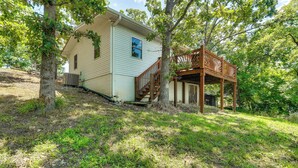 A single-story house with a wooden deck and a staircase leading to a covered porch. - Ozarks Waterfront Home w/ Dock & Marina Access (Warsaw)