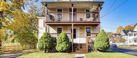A two-story house with a balcony, a front porch, and a driveway.