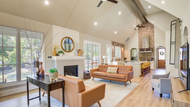 A spacious living area with a fireplace, a dining table, and a kitchen in the background. - Walk to Shops & Winery! Stylish Dtwn Ovilla Home (Red Oak)