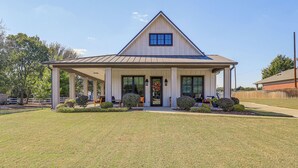 A single-story building with a gabled roof, a covered porch, and a front door. - Walk to Shops & Winery! Stylish Dtwn Ovilla Home (Red Oak)