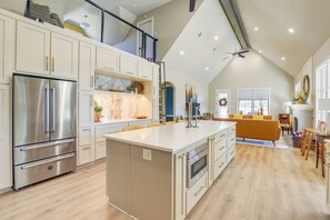 A spacious kitchen with a large island, stainless steel appliances, and a high ceiling with a fan. - Walk to Shops & Winery! Stylish Dtwn Ovilla Home (Red Oak)