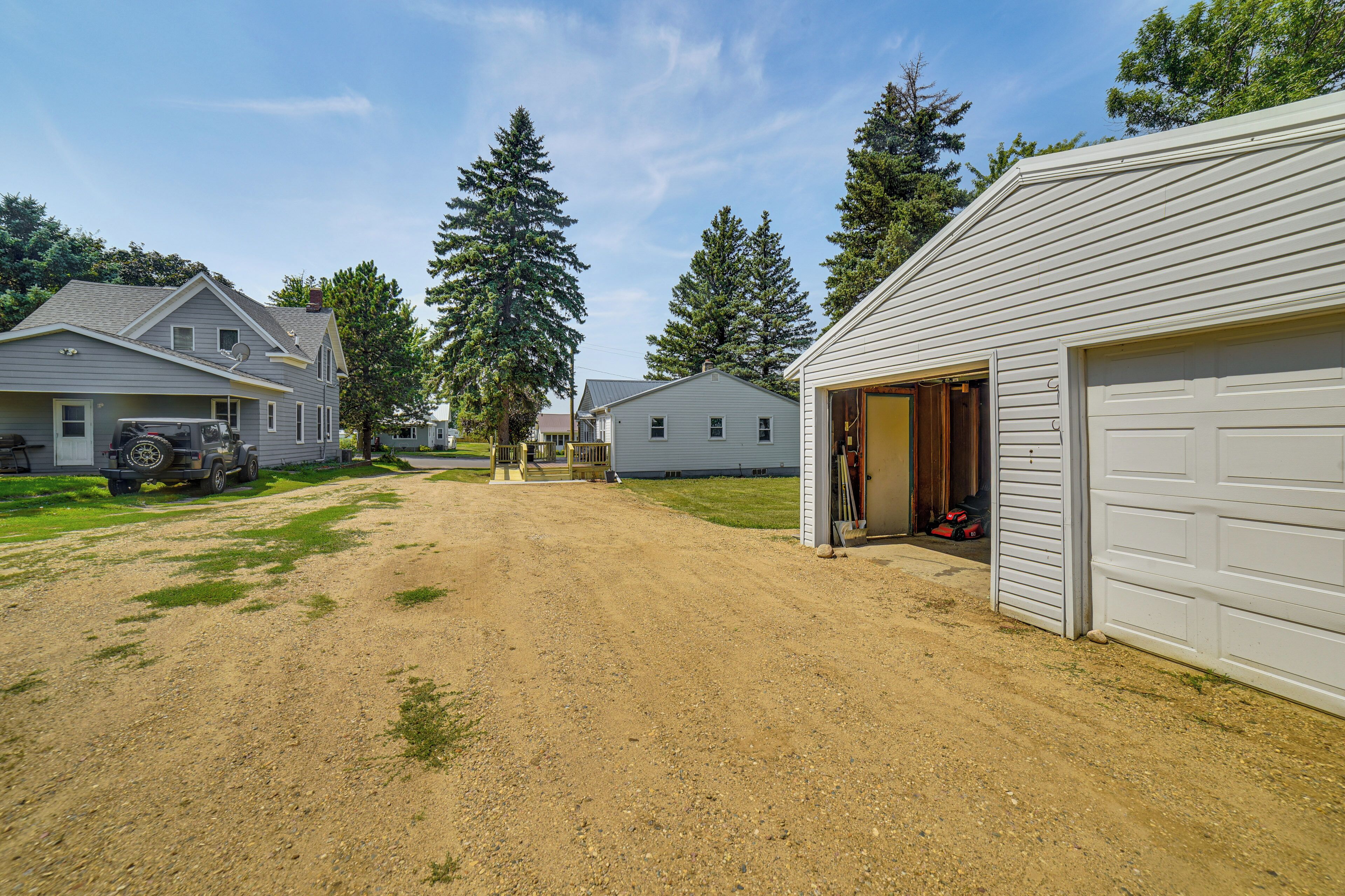 A residential area with houses, a gravel driveway, and a garage.