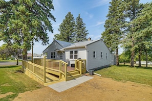 A single-story house with a covered porch and a small deck, surrounded by trees. - Gary Hunting & Fishing Base w/ Wraparound Deck (Gary)